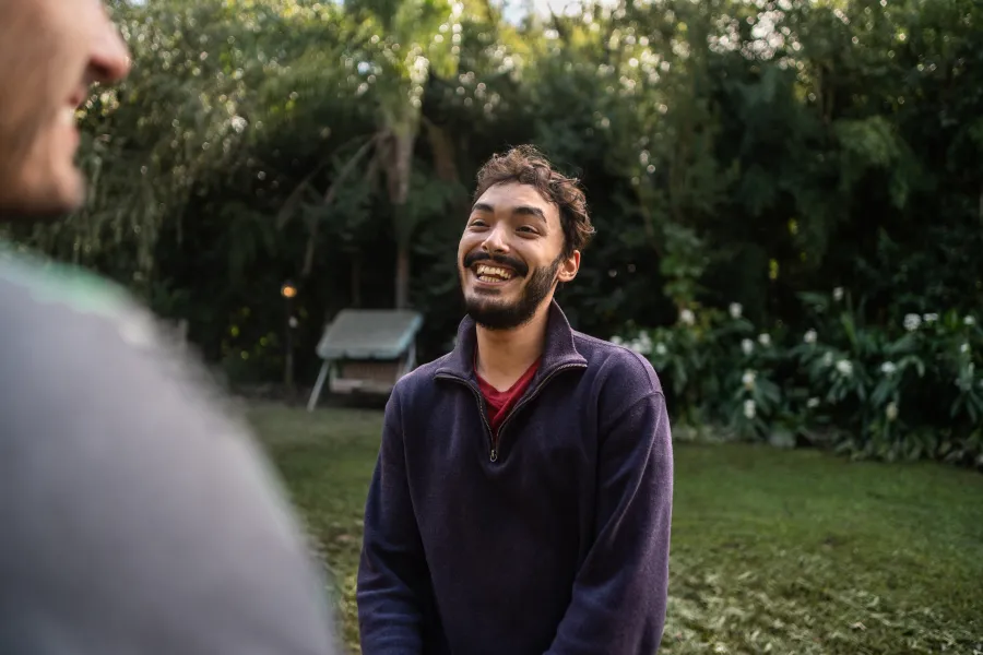 Hombre feliz en un parque tras contratar la Tarifa Solar con Batería Virtual de Repsol