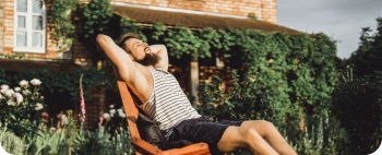 Hombre relajado descansando en el jardín de su casa con la Tarifa Tranquilísima de Repsol