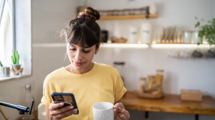 Mujer contratando la Tarifa de Precio Indexado para Pymes de Repsol mientras toma un café